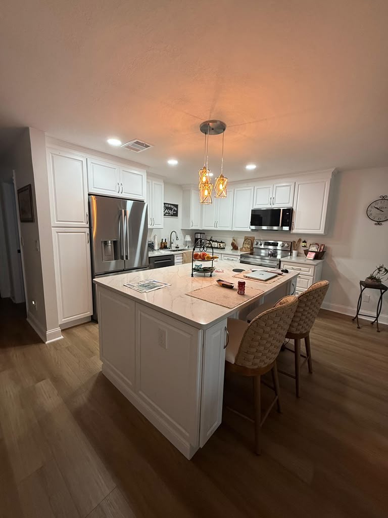 White Kitchen Island with Gold Veined Quartz and Wicker Stools